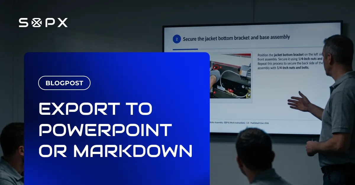 A supervisor seen from behind presenting an exported SOP slide on a wall display to a small group of seated workers in a meeting room.